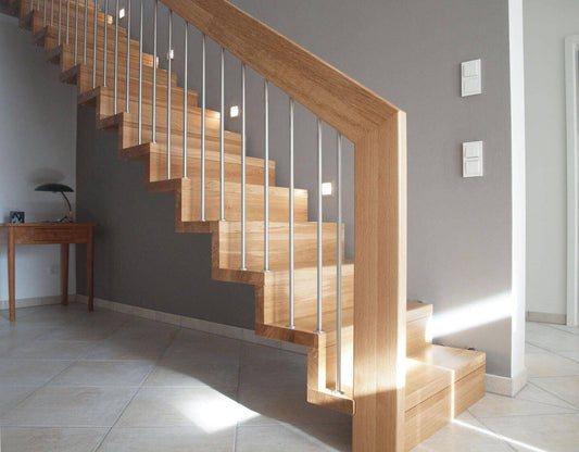 Holztreppe mit Glasgeländer und Wandeinbauleuchten in der Wand neben den Stufen